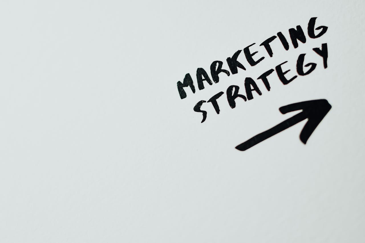 services-03 Close-up of handwritten Marketing Strategy text with an arrow on white background.