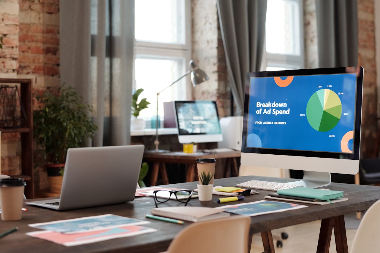 hero-img A modern office workspace featuring computers, charts, and office supplies for a productive environment.